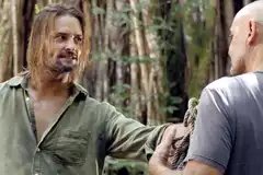 Sawyer (Josh Holloway) looks upset as he hands a rope to Locke (Terry O'Quinn) i