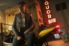 Lucia Caminos sites on a motorcycle outside of a bar in a still from Grand Theft Auto 6