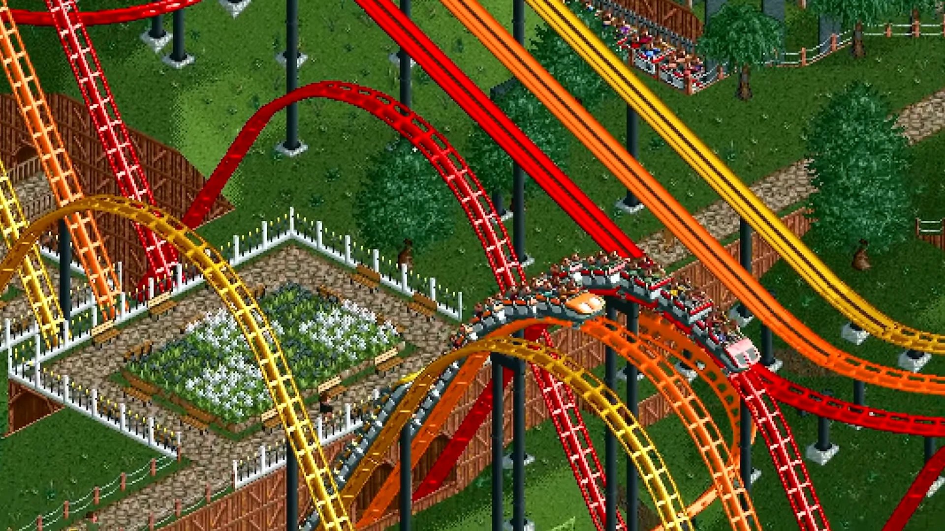 Screenshot of RollerCoaster Tycoon Classic showing competing red, orange, and yellow coasters
