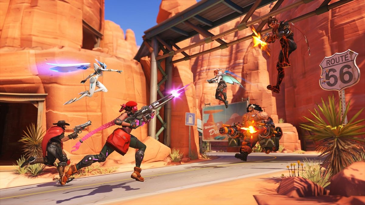 Overwatch tier list: Sierra, Cass, and Echo, firing at Emre, Freja, and Mauga ahead of them on Route 66.