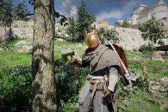 Kliff wearing a silly helmet and standing near a tree with a logging axe in Crimson Desert