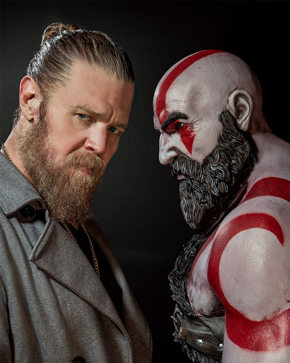 Ryan Hurst stands next to a figure of God of War's Kratos