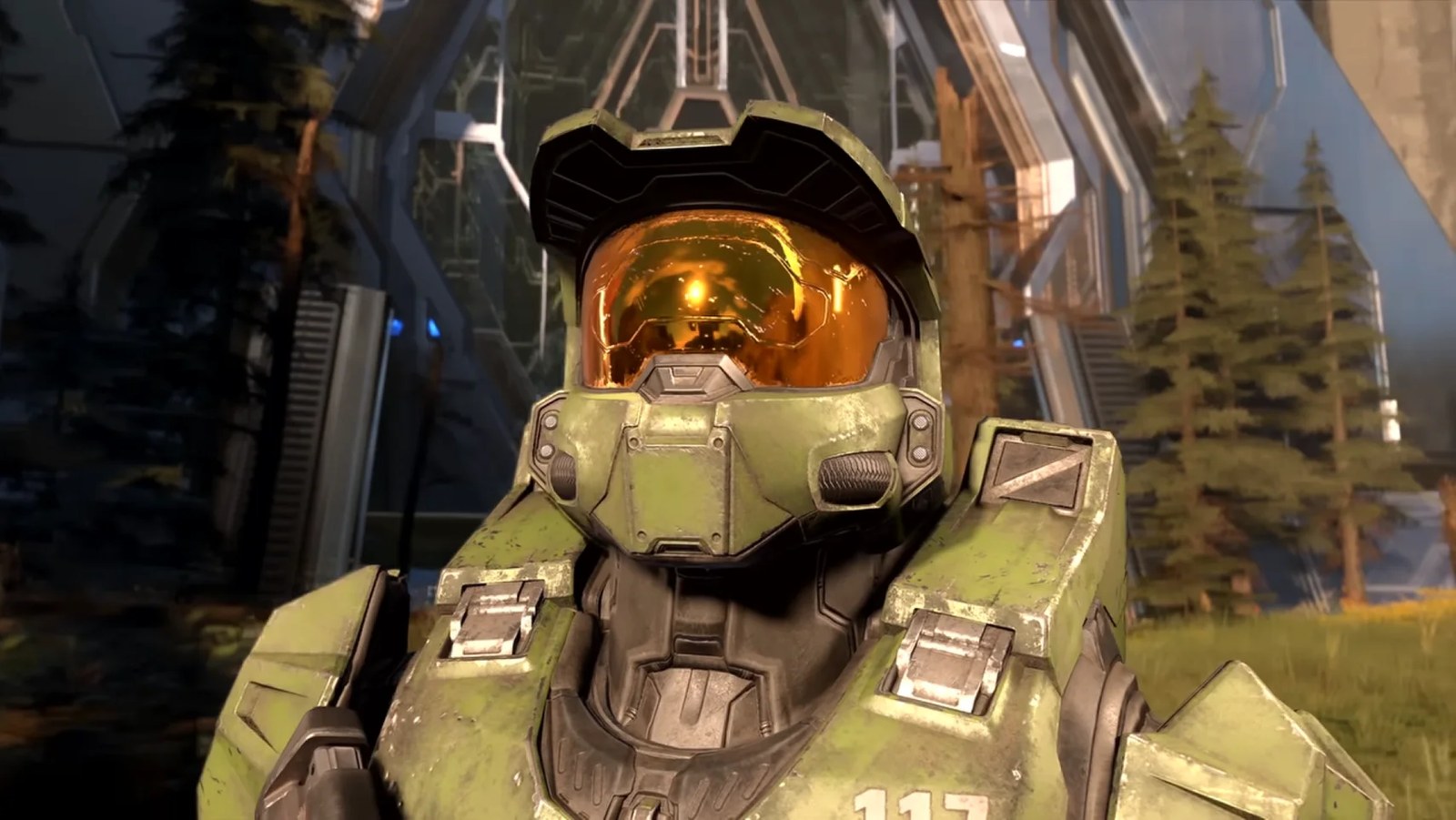 Master Chief stands in front of greenery and looks up at the sky in a screenshot from Halo Infinite.
