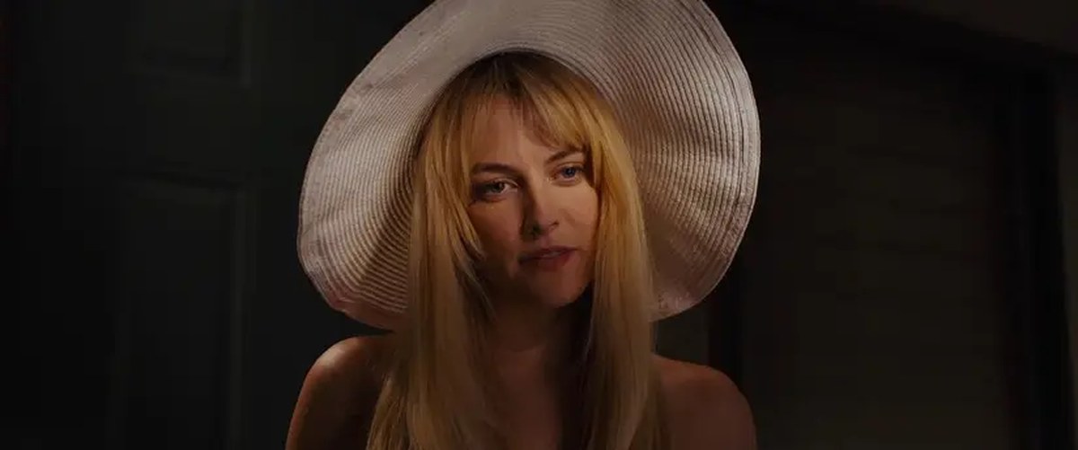 Sarah wears a mysterious expression while talking to Sam in Under the Silver Lake