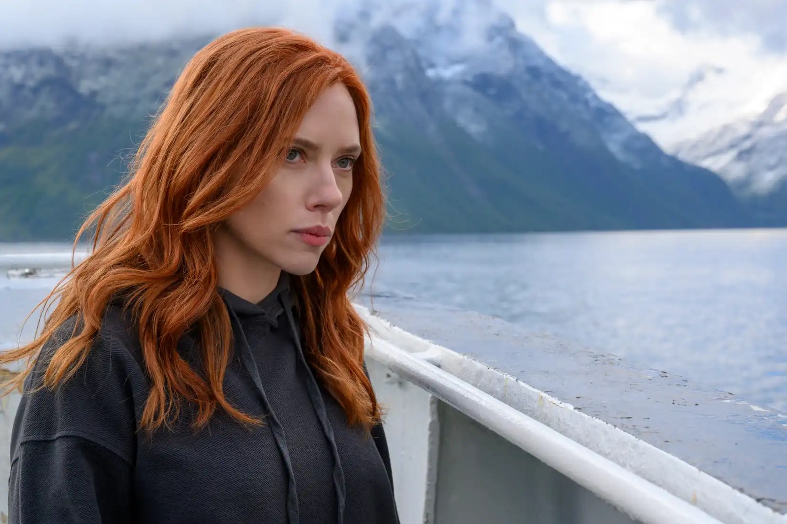 Scarlett Johansson, seen with long red hair standing on a ferryboat in Black Widow