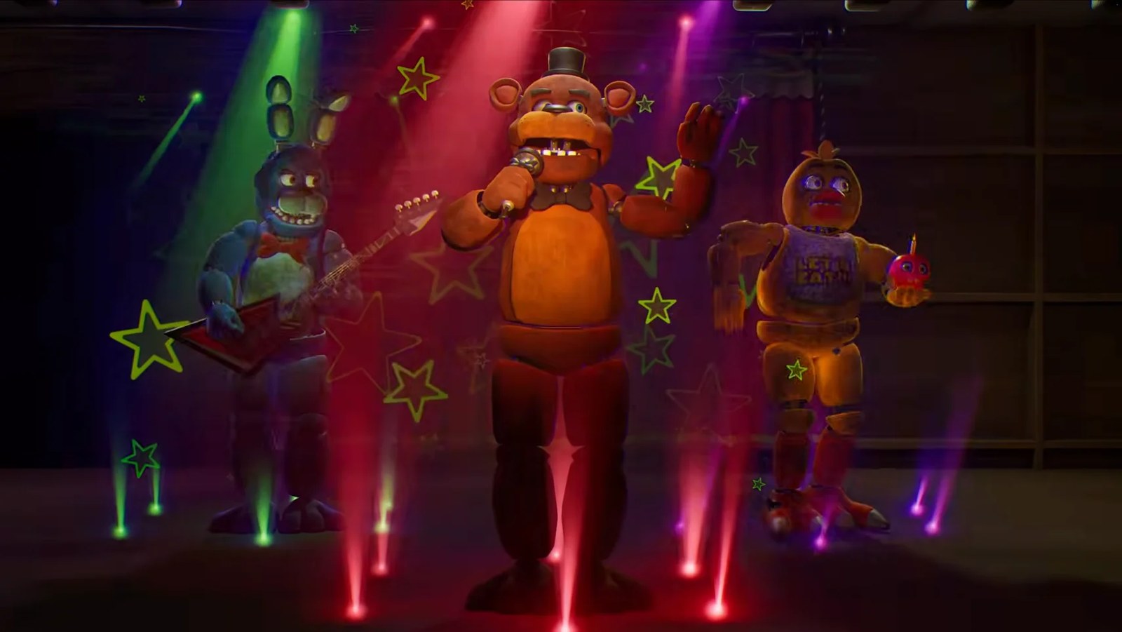 Three animatronic characters on a stage with colorful spotlights and glowing stars: a blue rabbit playing a red guitar, a brown bear wearing a top hat and singing into a microphone, and a yellow chicken holding a cupcake.