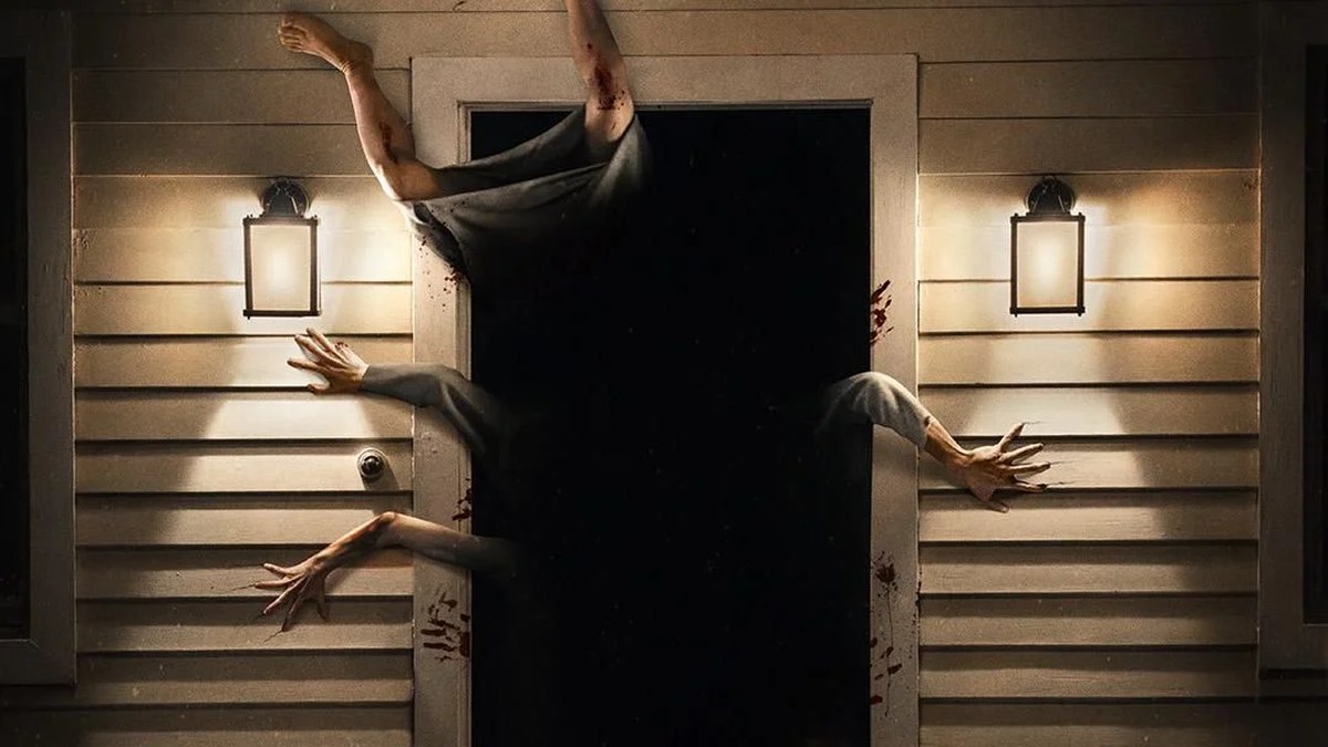 Many arms and a pair of legs burst out of a dark doorway lit either side by lantern lights.