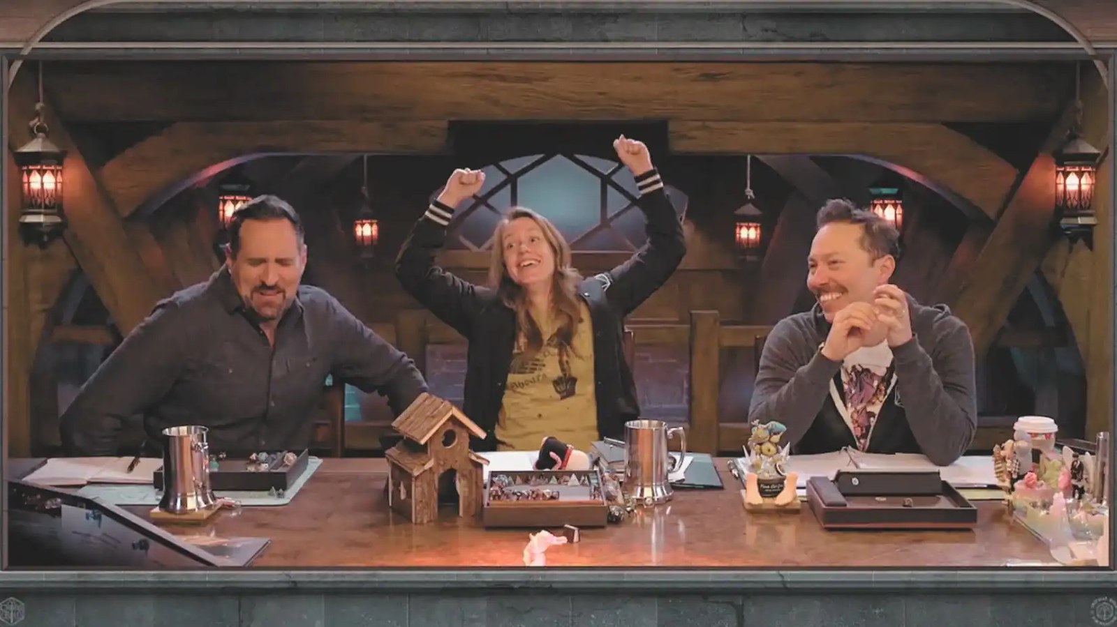 A screenshot of Critical Role's Travis Willingham, Marisha Ray, and Sam Riegel. All three are cheering loudly.